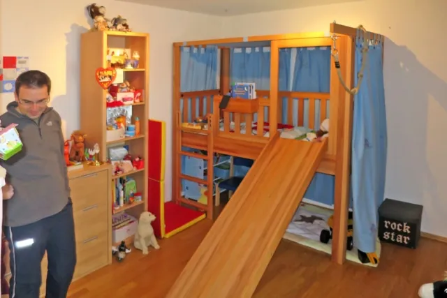 mitwachsendes Kinderbett aus Kernbuchenholz, mit Rutsche als Zubehör.